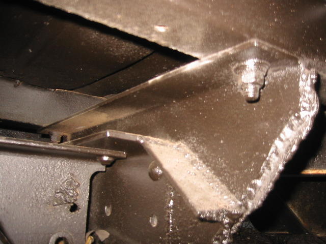 8001 - Rear of frame, note welds and cuts that are non original, but
original bracket is there, riveted to frame.  Upper right 